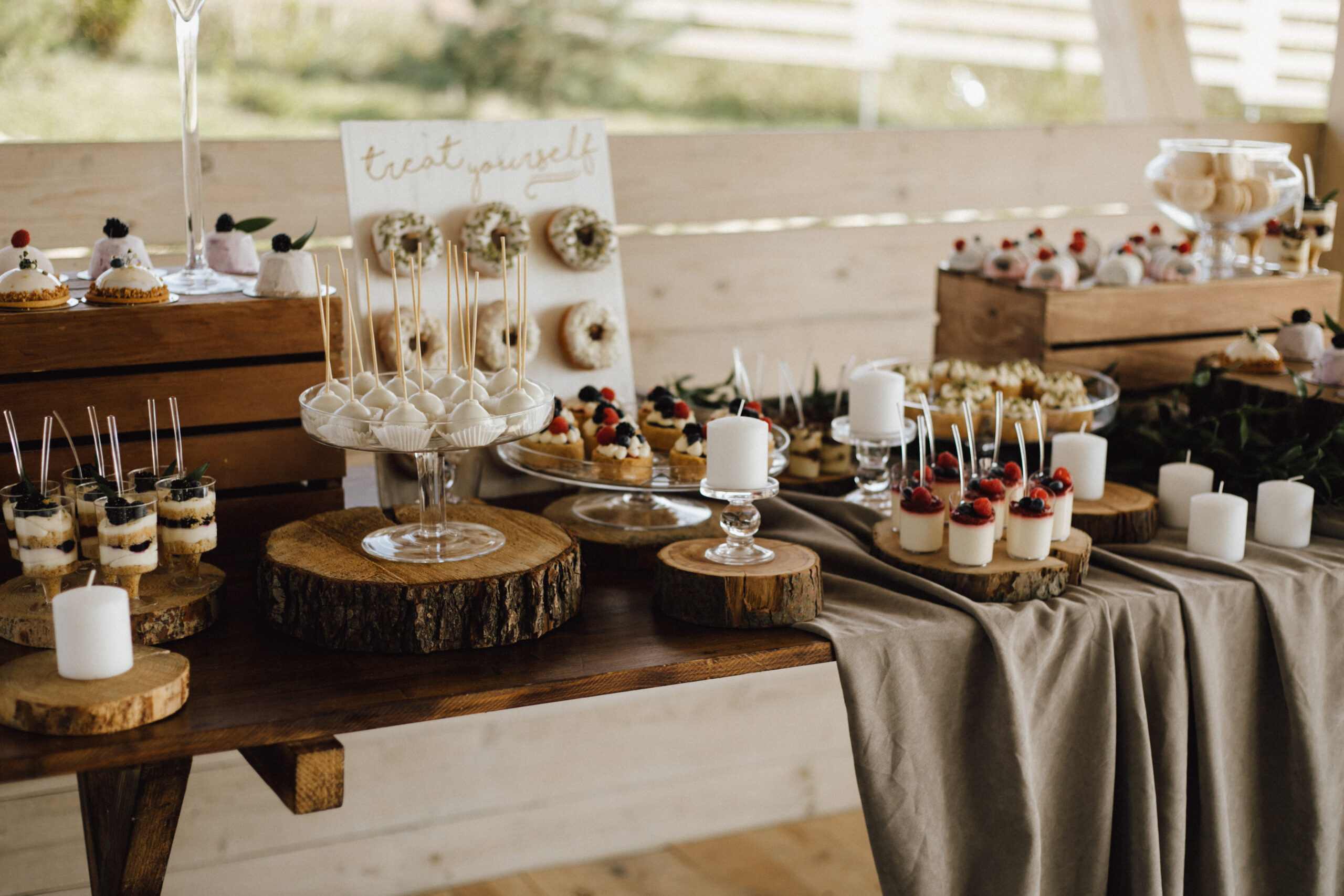 Top view of table full of sweet delicious desserts, cupcakes, donuts and panna cotta desserts, candy pops and tiramisu